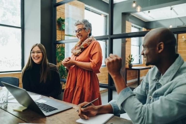 Middle-aged woman laughing with colleagues 
